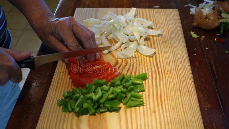 Un cocinero que corta los ingredientes en cuadritos para la quiche