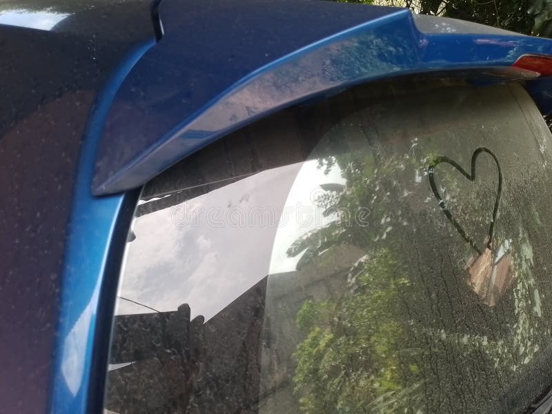 a heart drawn on the dusty rear window of a car. a heart drawn on the dusty rear window of a car