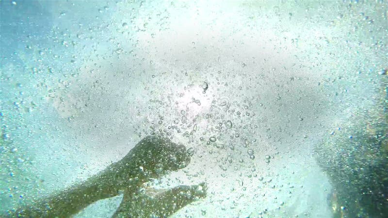 Un colpo subacqueo di un uomo di salto contro sole luminoso video di movimento lento