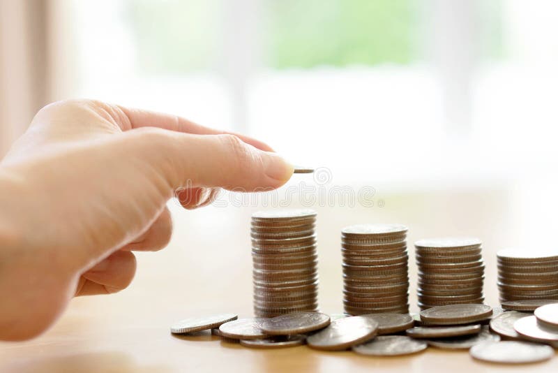 Un concepto del dinero del ahorro, mano masculina que pone el crecimiento de la pila de la moneda del dinero fotos de archivo libres de regalías Un concepto del dinero del ahorro, mano masculina que pone el crecimiento de la pila de la moneda del dinero fotos de archivo libres de regalías
