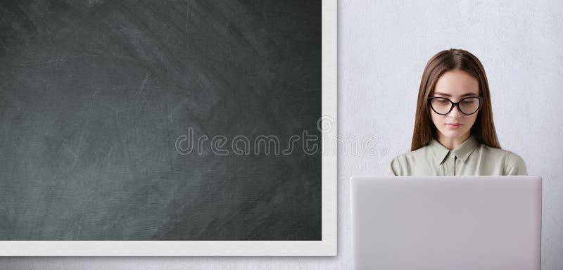 Un concepto educativo Colegiala bonita con el funcionamiento de vidrios largo del pelo que lleva oscuro con su ordenador portátil fotografía de archivo libre de regalías Un concepto educativo Colegiala bonita con el funcionamiento de vidrios largo del pelo que lleva oscuro con su ordenador portátil fotografía de archivo libre de regalías