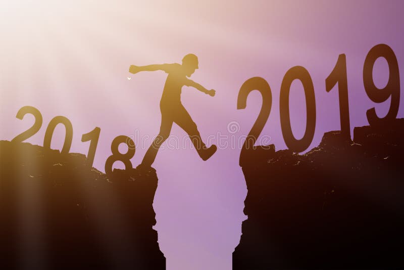 2019 New year concept, Silhouette Young man of architect walking and jumping to change 2018 between the 2019 New year on rock. 2019 New year concept, Silhouette Young man of architect walking and jumping to change 2018 between the 2019 New year on rock