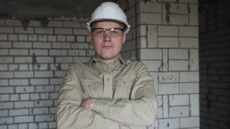 Un contremaître professionnel sur un chantier de construction dans un casque blanc et des lunettes