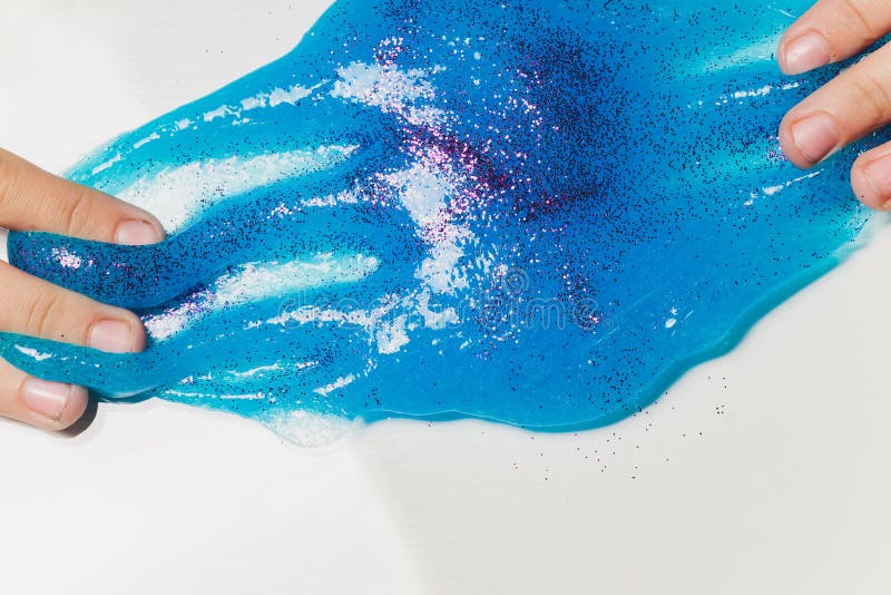 Un copil care se joacă de-a jucăria făcută de mână, numită Slime Alien Drool Shell Muschel. royalty free stock photography