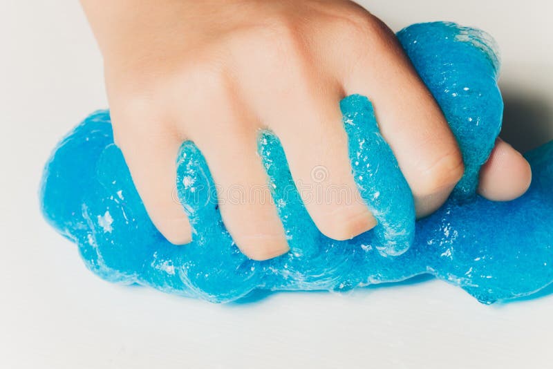Un copil care se joacă de-a jucăria făcută de mână, numită Slime Alien Drool Shell Muschel.