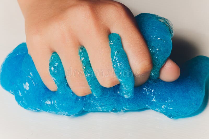 Un copil care se joacă de-a jucăria făcută de mână, numită Slime Alien Drool Shell Muschel. royalty free stock photo