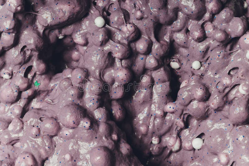 Un copil care se joacă de-a jucăria făcută de mână, numită Slime Alien Drool Shell Muschel. stock photo