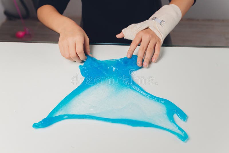 Un copil care se joacă de-a jucăria făcută de mână, numită Slime Alien Drool Shell Muschel. copiii se înmânează într-o distribuție stock photo