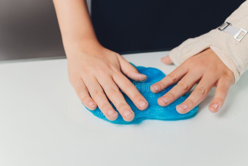 Un copil care se joacă de-a jucăria făcută de mână, numită Slime Alien Drool Shell Muschel. copiii se înmânează într-o distribuție stock image