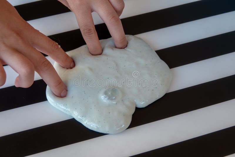 Un copil care se juca de-a mâna a făcut o jucărie numită noroi pe fond alb și negru stock photography