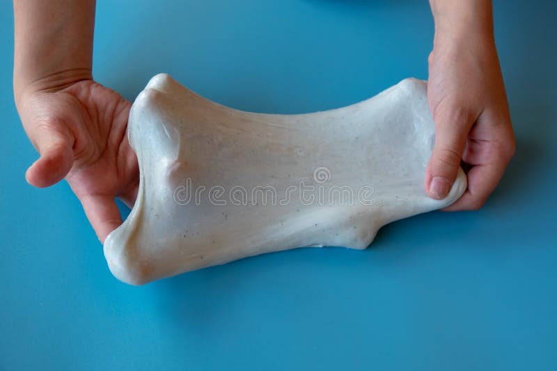 Un copil care se juca de-a mâna a făcut o jucărie numită noroi pe fond albastru royalty free stock photos