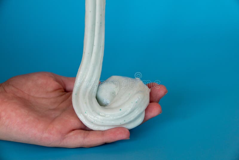 Un copil care se juca de-a mâna a făcut o jucărie numită noroi pe fond albastru royalty free stock image
