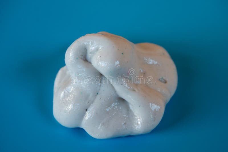 Un copil care se juca de-a mâna a făcut o jucărie numită noroi pe fond albastru royalty free stock photo