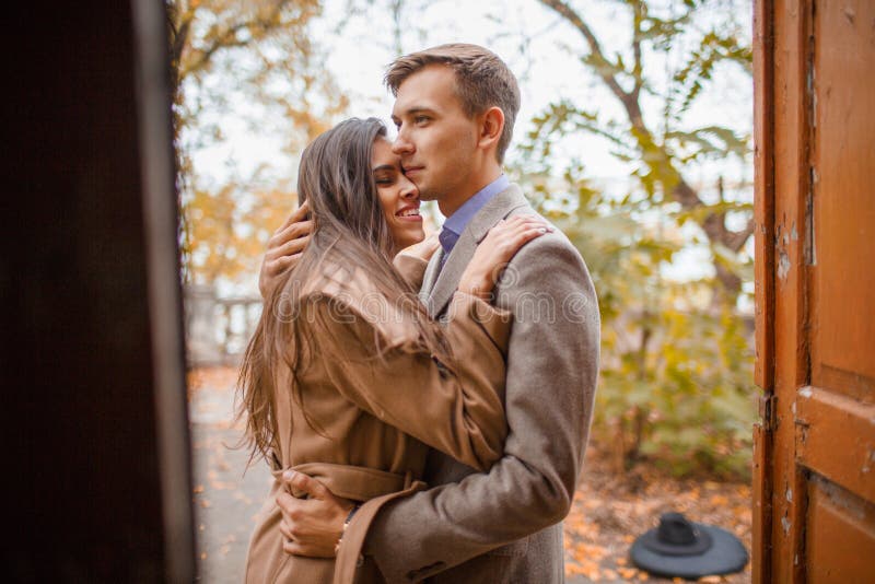 Un couple affectueux étreignant la position à la porte dehors en parc d'automne image libre de droits Un couple affectueux étreignant la position à la porte dehors en parc d'automne image libre de droits