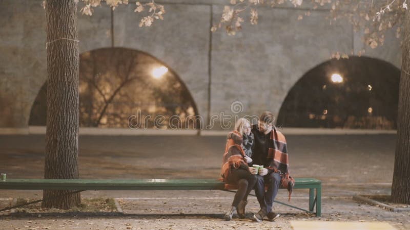 Un couple attrayant dans l'amour embrasse et apprécie un moment intime ensemble, contre le contexte des lumières de ville