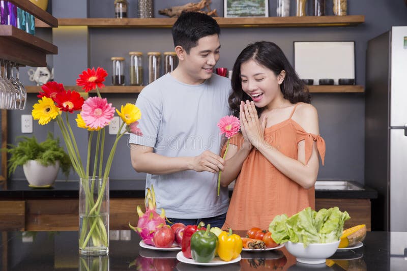 Un couple dans la cuisine avec beaucoup de fruits et légumes image libre de droits Un couple dans la cuisine avec beaucoup de fruits et légumes image libre de droits