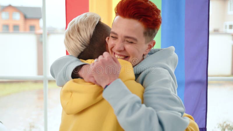 Un couple s'embrasse joyeusement devant un arc-en-ciel vibrant partageant son amour et sa joie banque de vidéos