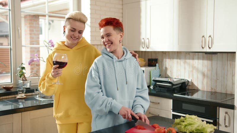 Un couple se cuisinant ensemble dans une cuisine confortable partageant le rire et le temps de qualité banque de vidéos