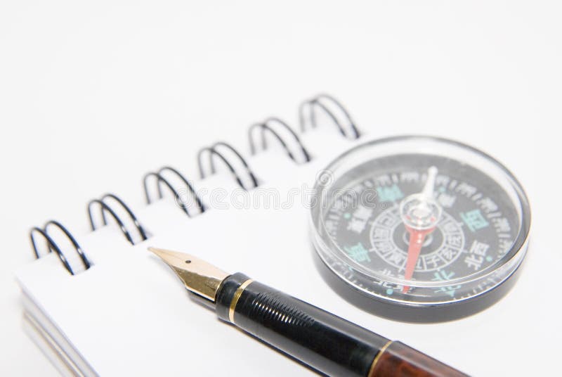 A pen and compass on note book,on white. A pen and compass on note book,on white