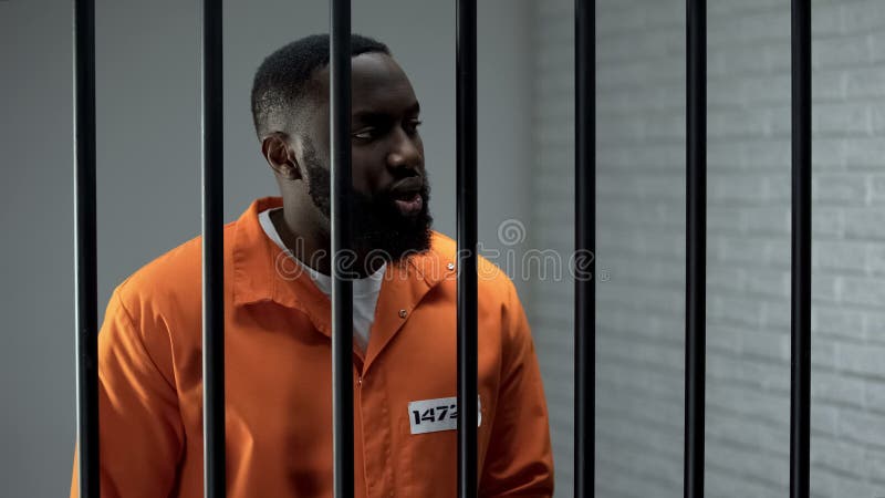 Un criminel afro-américain purgeant une peine de prison, en attente d'un gardien de prison photographie stock