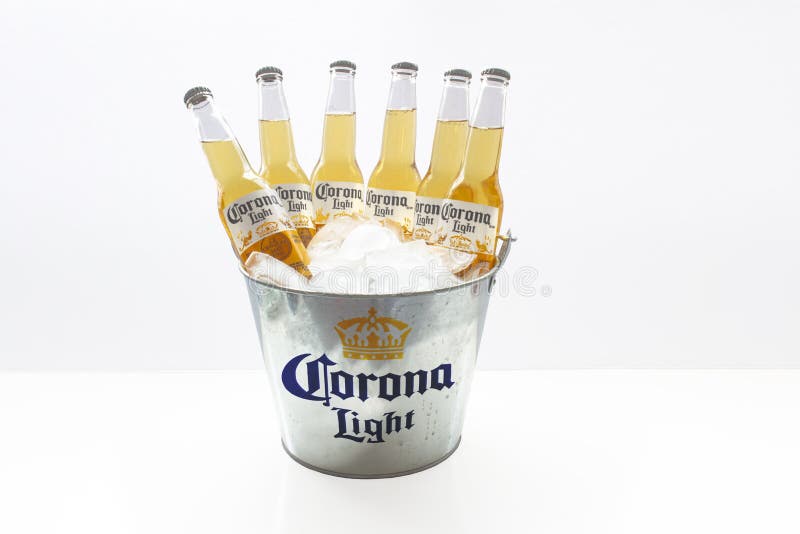 Un cubo de cerveza de corona light beers bottle con hielo sobre fondo blanco imagen de archivo