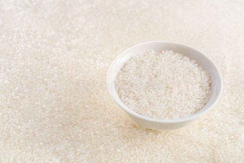 Un cuenco de arroz con los oídos del arroz en el fondo fotografía de archivo libre de regalías Un cuenco de arroz con los oídos del arroz en el fondo fotografía de archivo libre de regalías