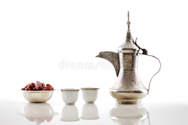 Un dallah, un vaso del metallo per produrre caffè arabo con una ciotola di datteri secchi