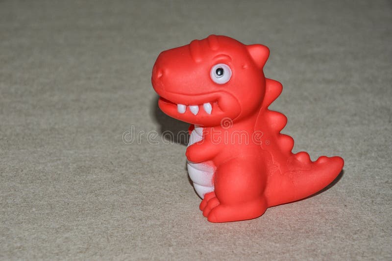 Un dinosaure de jouet rouge de jouet pour enfants photos libres de droits Un dinosaure de jouet rouge de jouet pour enfants photos libres de droits