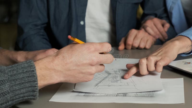 Un diseñador dibuja un bosquejo de diseño de cocina en una reunión con una pareja joven La joven familia elige el diseño interior