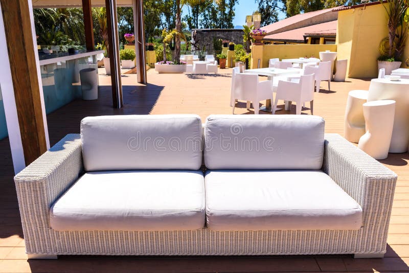 Un divano bianco comodo su un terrazzo pubblico all'aperto per bevande vicino a una spiaggia del Mediterraneo fotografie stock libere da diritti Un divano bianco comodo su un terrazzo pubblico all'aperto per bevande vicino a una spiaggia del Mediterraneo fotografie stock libere da diritti