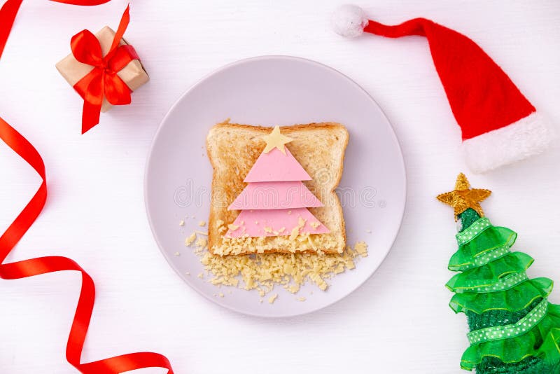 Un divertido sándwich con un árbol de Navidad comestible hecho de pan tostado, salchichas y queso Idea para desayunos para niños fotografía de archivo