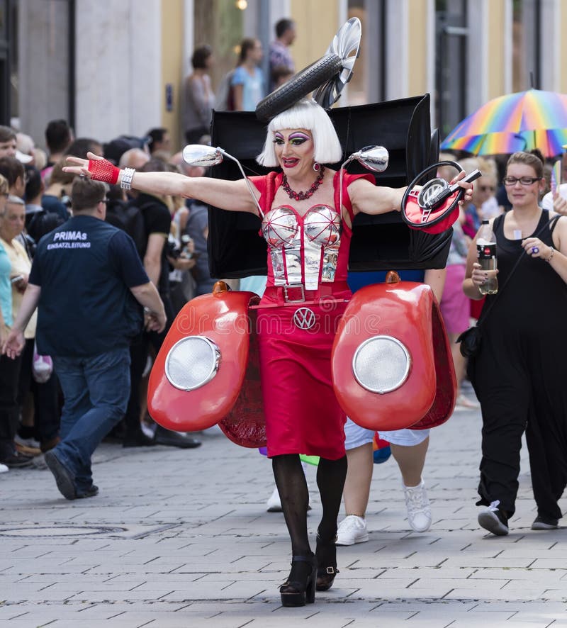 018: Un drag queen agghindato come un'automobile rossa femminile di Volkswagen che assiste alla parata di Gay Pride anche conosci fotografia stock 018: Un drag queen agghindato come un'automobile rossa femminile di Volkswagen che assiste alla parata di Gay Pride anche conosci fotografia stock