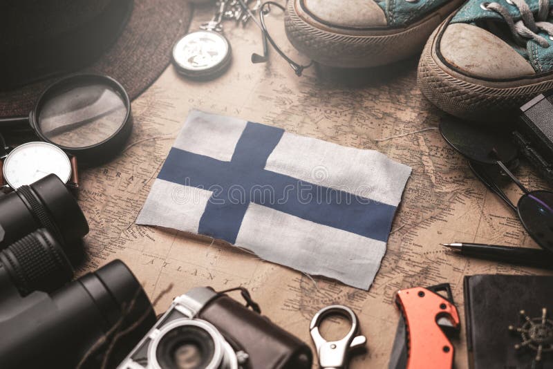 Un drapeau finlandais entre les accessoires du voyageur et la carte de l'ancien millésime Concept de destination touristique images libres de droits Un drapeau finlandais entre les accessoires du voyageur et la carte de l'ancien millésime Concept de destination touristique images libres de droits