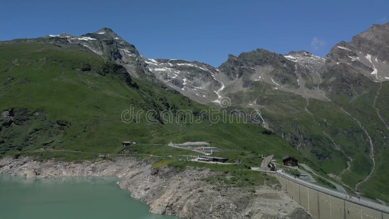 Un drone au-dessus du Stausee Mooserboden eaux turquoise reflétant des falaises déchiquetées dans les Alpes autrichiennes banque de vidéos