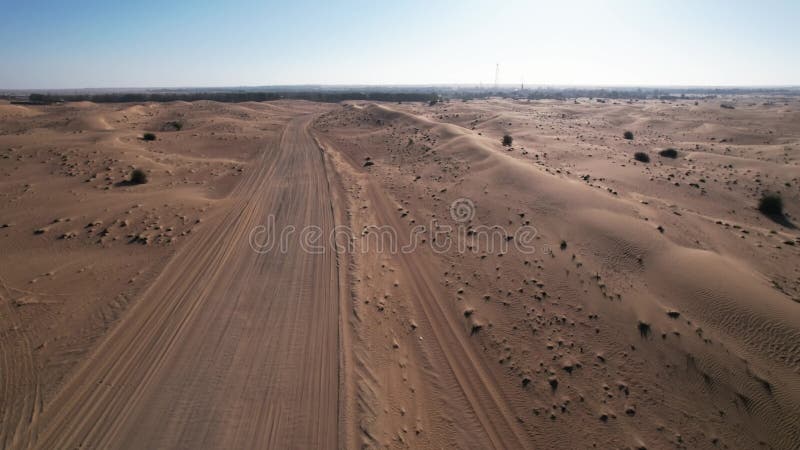 Un drone sur les dunes de sable du désert à Dubaï. Une journée ensoleillée d'été une route déserte. banque de vidéos