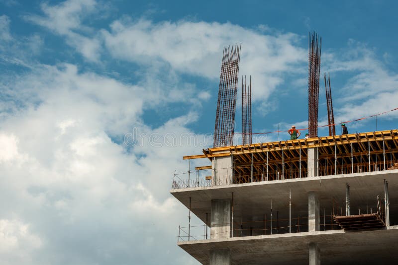 Un edificio bajo construcción con algunos pequeños trabajadores contra el cielo Torre del edificio del proyecto del concepto.