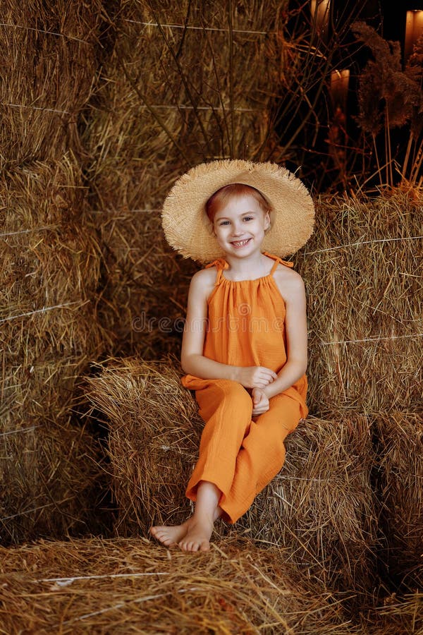 Un Enfant Aux Filles En Costume Orange Et Chapeau De Paille Posé Sur Un  Foin Image stock - Image du mignon, pile: 277453437