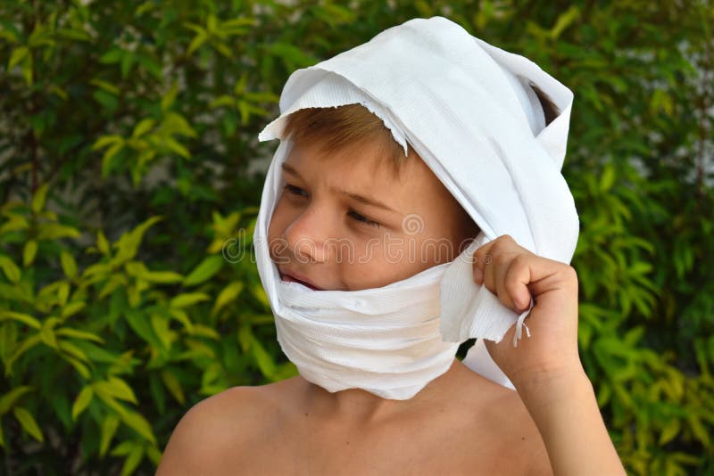 Un enfant en costume de momie Le garçon s'est enveloppé dans du papier toilette Un petit garçon est en train de jouer à la momie photo stock Un enfant en costume de momie Le garçon s'est enveloppé dans du papier toilette Un petit garçon est en train de jouer à la momie photo stock