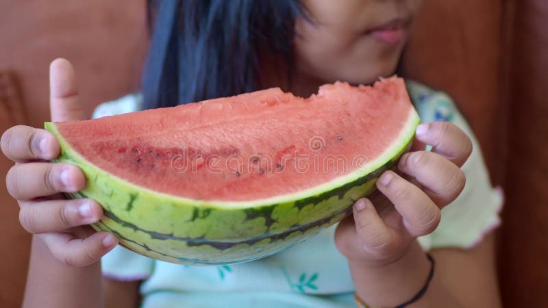 Un enfant joyeux qui profite d'une délicieuse tranche de pastèque fraîche banque de vidéos