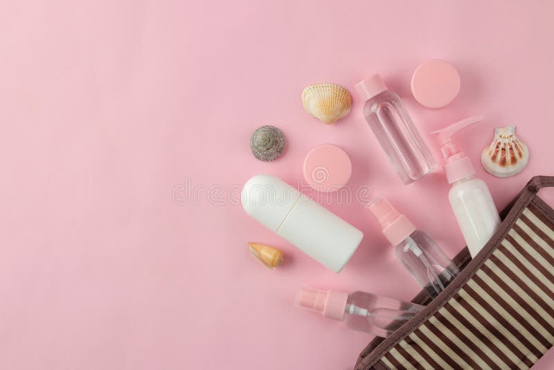 Un ensemble de cosmétiques et de produits de soin personnel pour le voyage dans un sac cosmétique sur un fond rose-clair Vue sup? images stock Un ensemble de cosmétiques et de produits de soin personnel pour le voyage dans un sac cosmétique sur un fond rose-clair Vue sup? images stock