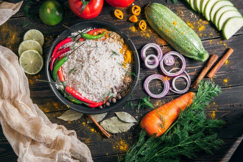 Un ensemble de produits pour la préparation du pilaf indien du riz et des légumes avec des épices, la vue supérieure images libres de droits Un ensemble de produits pour la préparation du pilaf indien du riz et des légumes avec des épices, la vue supérieure images libres de droits