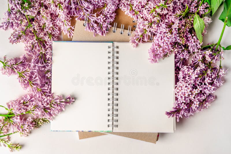 Un espace de travail avec papier de note et composition florale lilas. magnifique arrière-plan de ressort avec espace pour la vue photos stock