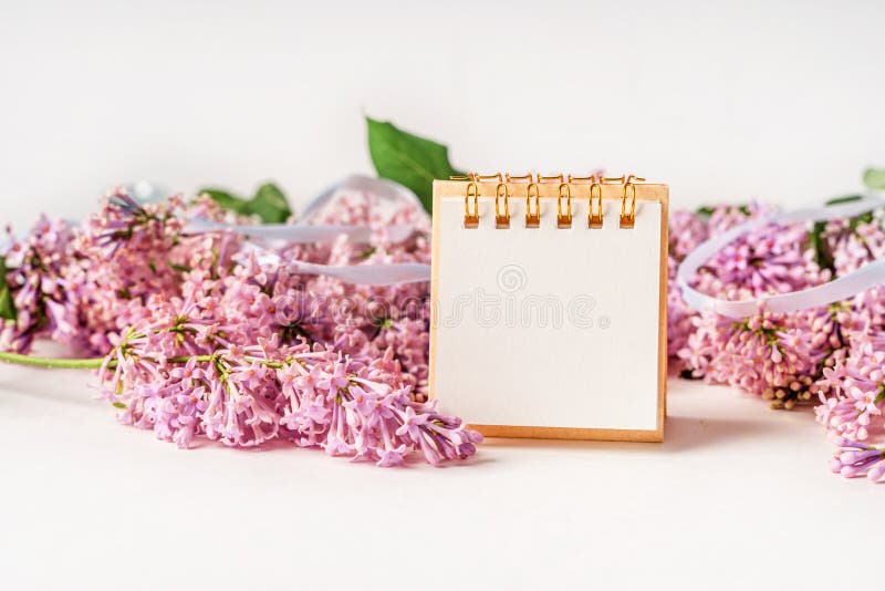 Un espace de travail avec papier de note et composition florale lilas. magnifique arrière-plan de ressort avec espace pour la vue photos libres de droits