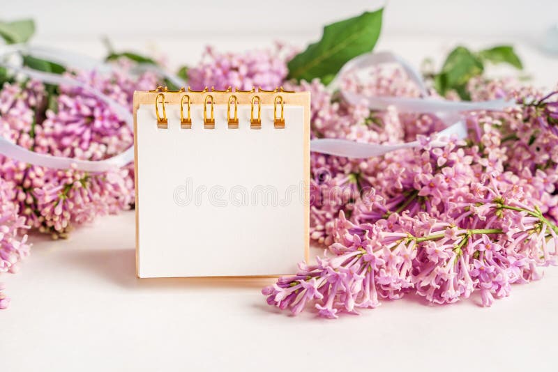 Un espace de travail avec papier de note et composition florale lilas. magnifique arrière-plan de ressort avec espace pour la vue photo libre de droits