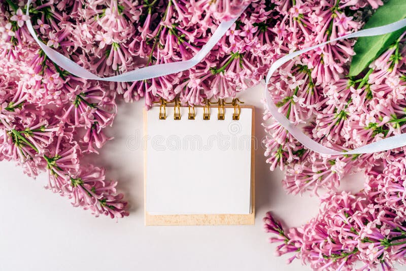 Un espace de travail avec papier de note et composition florale lilas. magnifique arrière-plan de ressort avec espace pour la vue photographie stock libre de droits