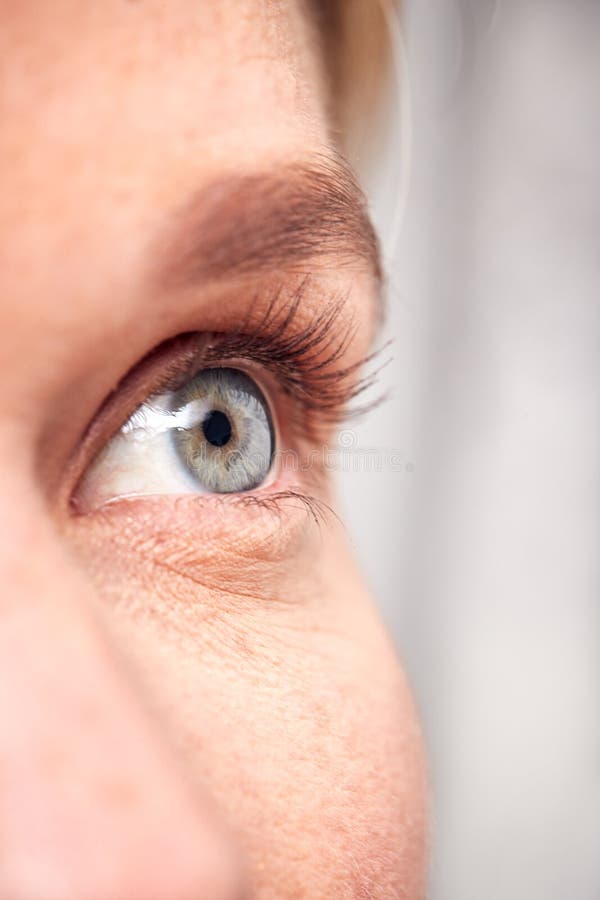 Un'Estrema Vicina All'Occhio Di Una Donna Sullo Sfondo Dello Studio Bianco immagini stock Un'Estrema Vicina All'Occhio Di Una Donna Sullo Sfondo Dello Studio Bianco immagini stock