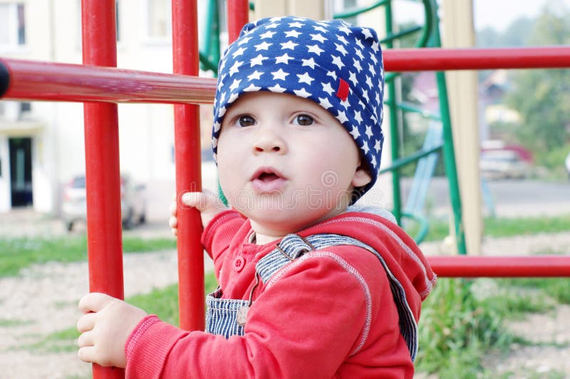Un'età del bambino di 10 mesi sul campo da giuoco immagine stock Un'età del bambino di 10 mesi sul campo da giuoco immagine stock