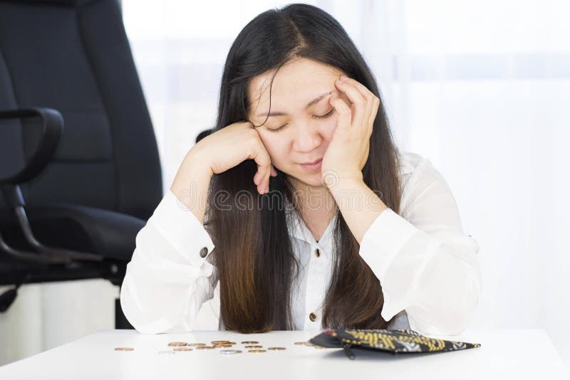 Un fallimento, si è rotto e la donna frustrata sta avendo problemi finanziari con le monete lasciate sulla tavola e su un portafo fotografia stock Un fallimento, si è rotto e la donna frustrata sta avendo problemi finanziari con le monete lasciate sulla tavola e su un portafo fotografia stock