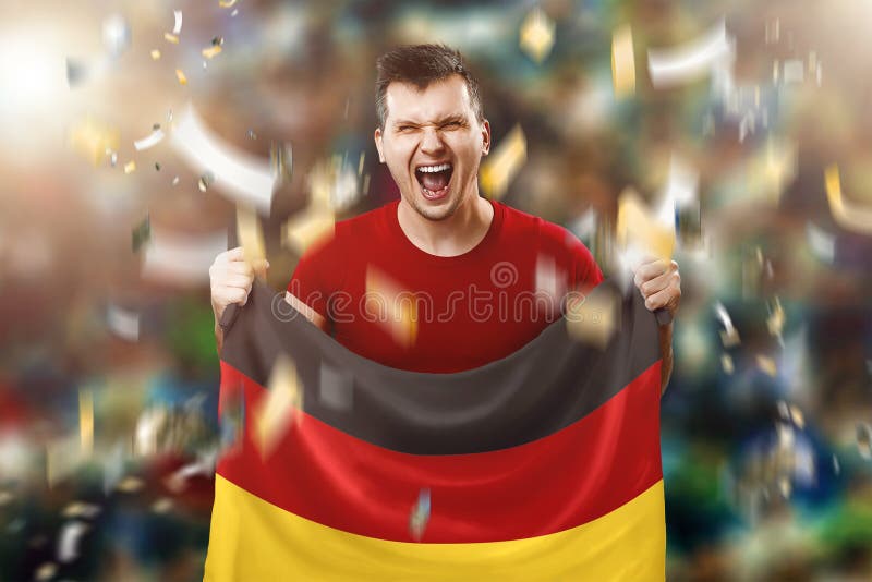 Un fan alemán, fan de un hombre que sostiene la bandera nacional de Alemania en sus manos Aficionado al fútbol en el estadio T?cn imagen de archivo libre de regalías Un fan alemán, fan de un hombre que sostiene la bandera nacional de Alemania en sus manos Aficionado al fútbol en el estadio T?cn imagen de archivo libre de regalías