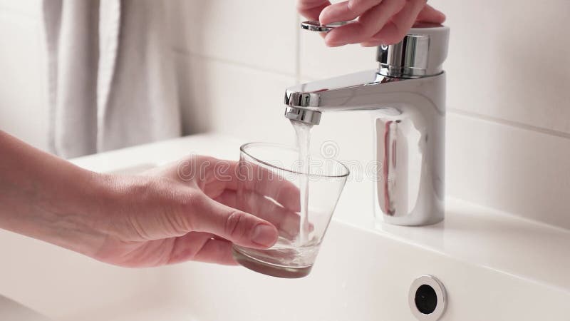 Un flux de boisson d'eau propre s'écoule dans le verre. banque de vidéos